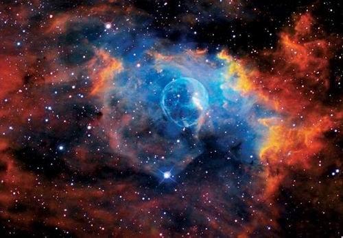 這是著名的“氣泡星云”（Bubble Nebula），這是一個(gè)灰塵氣體星云，其直徑為10光年，相當(dāng)于60萬億英里。氣泡星云是由一顆恒星燃燒時(shí)的脫離物質(zhì)構(gòu)成，恒星燃燒時(shí)可釋放出太陽數(shù)百倍亮度的光芒。該星云距離地球11000光年，位于仙后星座。