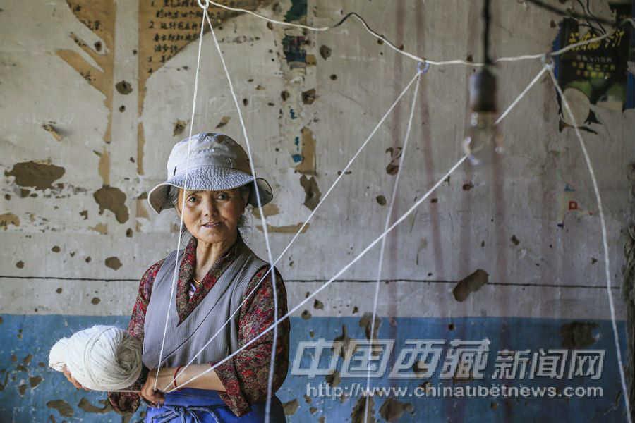 將線繞成這樣的形狀備用。央宗，46歲，林周縣人。從30歲開(kāi)始到拉薩地毯廠，從事倒線球的工作。
