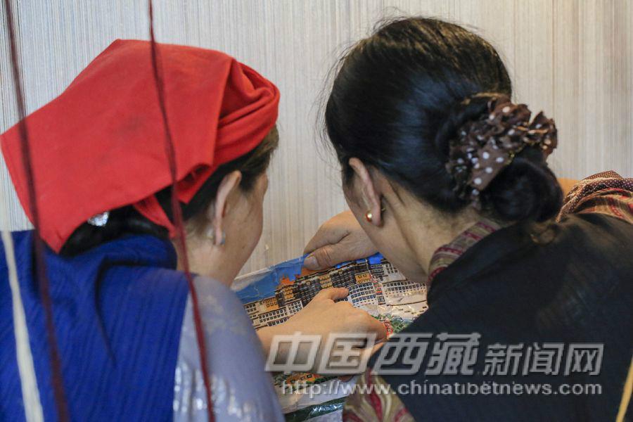這次是要織一幅長(zhǎng)4.5米、寬2.7米的掛毯，圖案就布達(dá)拉宮——這樣的圖案她們已經(jīng)編織了很多次，根本不需要在經(jīng)線上把圖案畫(huà)出來(lái)，偶爾看看打印出來(lái)的彩色圖紙就可以了。
