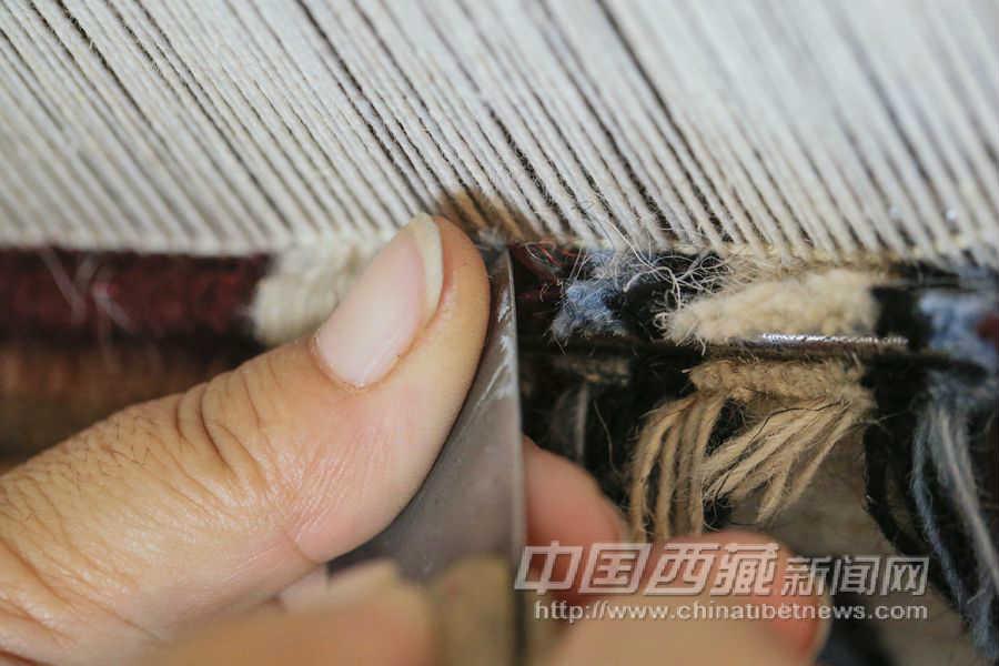 用鋒利的“筢子”沿著編織針將線割斷。