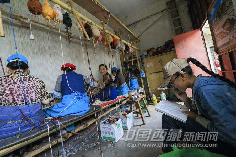編織工作非常辛苦，從早忙到晚，沒(méi)有時(shí)間照顧孩子，孩子們放學(xué)之后就在車間里學(xué)習(xí)。巴桑拉姆（右）今年13歲，是次仁拉姆的孩子，在拉薩市第一中學(xué)上初一。
