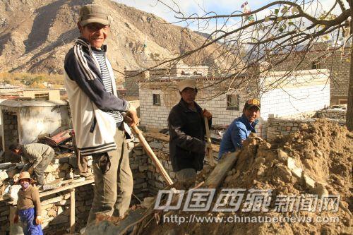正在蓋房子的村民熱情地招呼記者拍照。