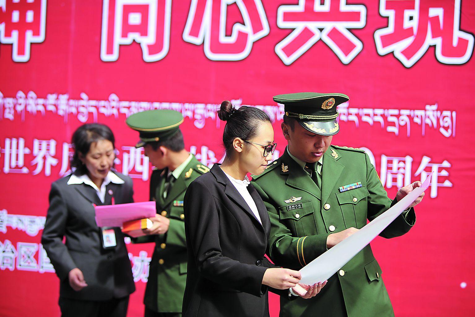 圖為邊防官兵在向過往群眾介紹全民國防教育日情況。