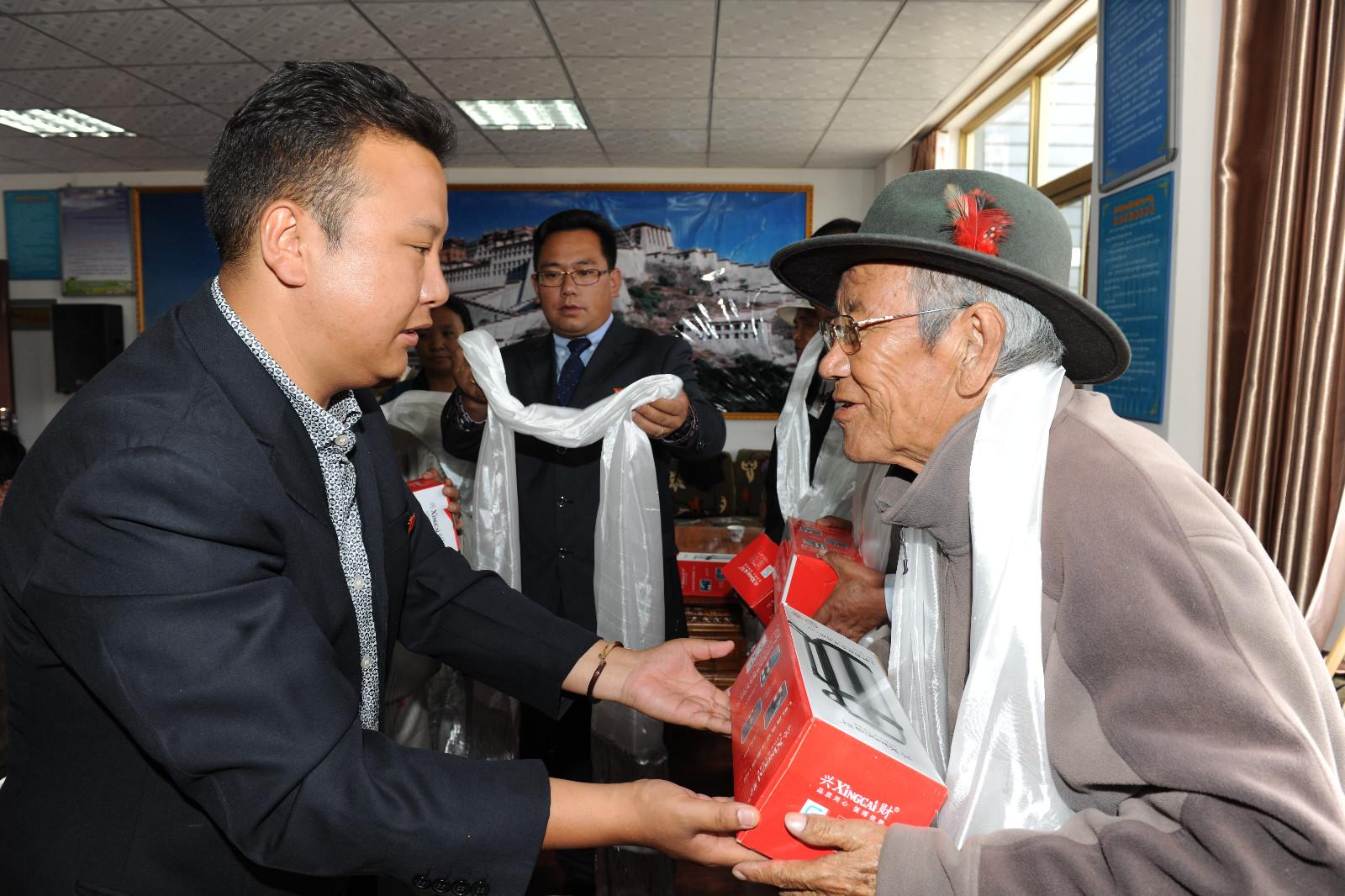 7月1日拉薩市城關(guān)區(qū)策門林社區(qū)居委會組織黨員召開座談會、開展了慰問老黨員、參觀愛國主義教育基地等內(nèi)容豐富的紀(jì)念活動，進(jìn)一步增強(qiáng)了黨員的黨性觀念，激發(fā)了廣大黨員愛黨、愛國、愛崗熱情，用實(shí)際行動向黨的生日獻(xiàn)禮。圖為7月1日,居委會第一書記尼瑪頓珠給老黨員發(fā)放慰問品。記者 旦增 攝