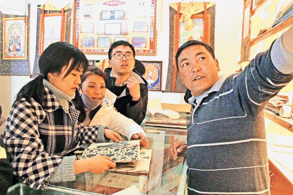 在合作社產(chǎn)品展示廳內(nèi)，社員向前來參觀的市民介紹藏紙產(chǎn)品。