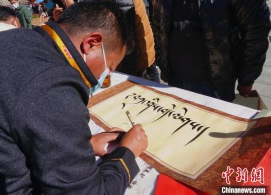 圖為書(shū)法家展示藏文書(shū)法?！∪轿木?攝