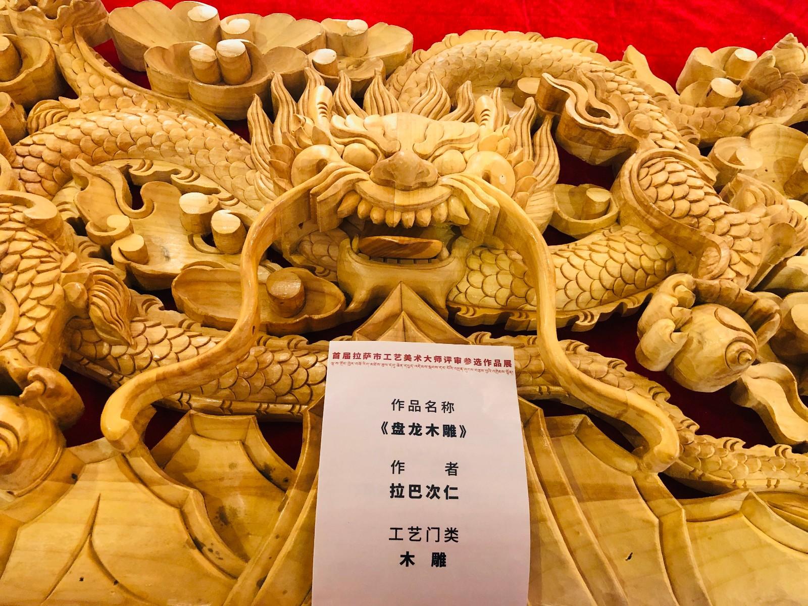 為了推動(dòng)拉薩民族手工業(yè)高質(zhì)量發(fā)展，促進(jìn)工藝美術(shù)產(chǎn)品設(shè)計(jì)開發(fā)與創(chuàng)新，豐富和拓展工藝美術(shù)的應(yīng)用和市場，振興和繁榮特色優(yōu)勢產(chǎn)業(yè)，提升行業(yè)知名度和美譽(yù)度，近日，首屆拉薩市工藝美術(shù)大師評審活動(dòng)在拉薩啟動(dòng)。圖為首屆拉薩市工藝美術(shù)大師評審活動(dòng)參選作品——盤龍木雕。