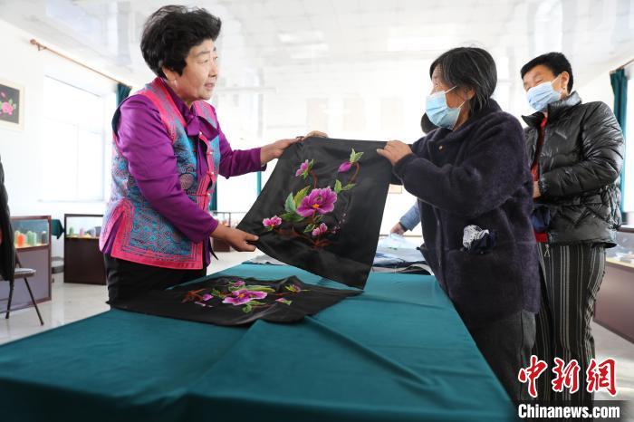 圖為白晶瑩驗收繡工的作品?！】朴抑衅煨麄鞑抗﹫D