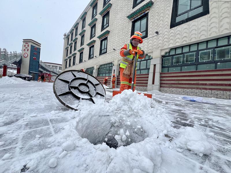 圖為環(huán)衛(wèi)工人在北京路街頭清理人行道上的積雪。記者 潘多 攝
