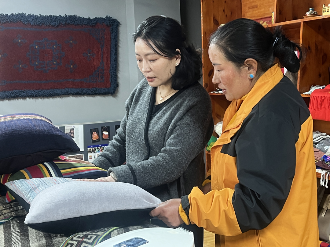 卓瑪心想，如果能通過“手藝研究+手作體驗(yàn)+手藝培訓(xùn)”的商業(yè)模式，開一家民族手工藝品店，讓來(lái)自全國(guó)各地的游客擁有一份只屬于西藏的伴手禮，還能解決婦女的就業(yè)問題，一定很有意義。2019年，西藏卓番林文化有限公司投入運(yùn)營(yíng)。圖為卓瑪（左一）與基層?jì)D女探討產(chǎn)品銷售問題。
